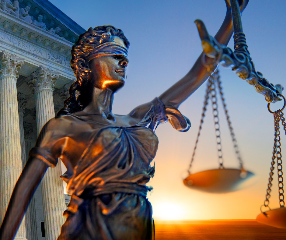 Lady Justice hold scales to represent the impartiality of the court's decisions in front of a sunset cascading over the U.S. Supreme Court